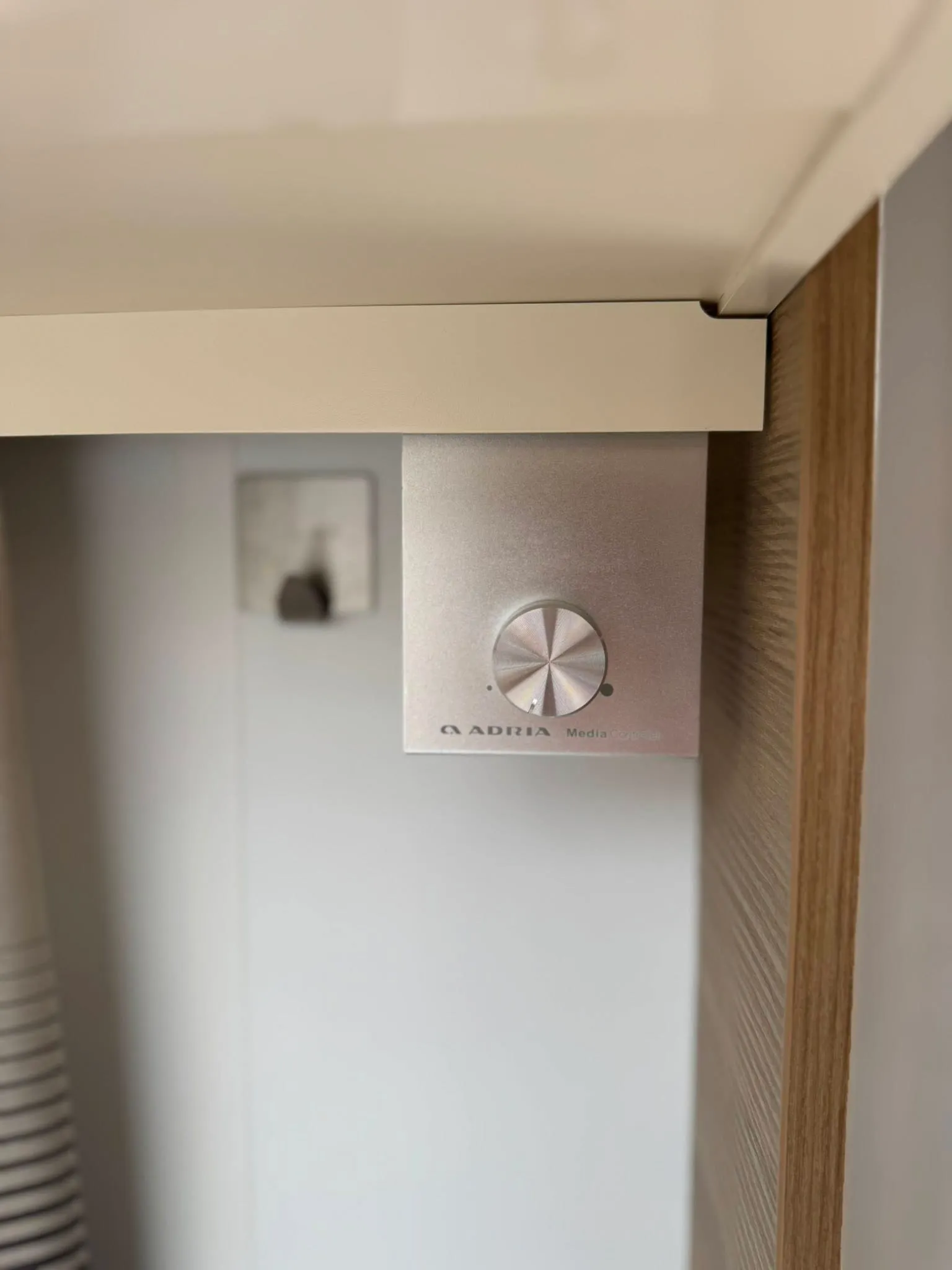 Obrázek zobrazuje ovládací prvek systému Adria Media ve vozidle. Ideální doplněk pro obytné auto nebo karavan.