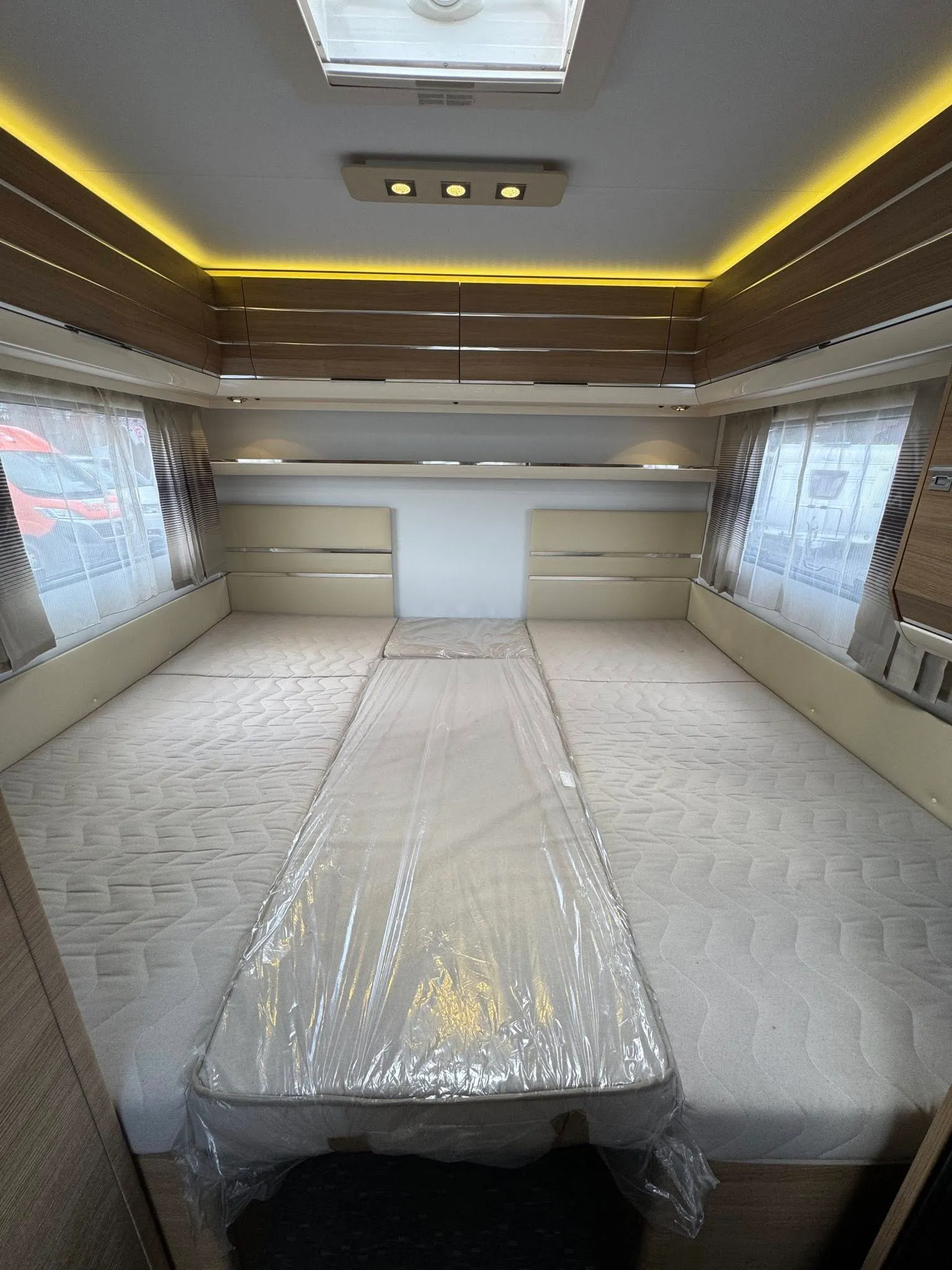 Interiér karavanu s postelemi a moderním osvětlením. Skvělý prostor pro odpočinek na cestách.