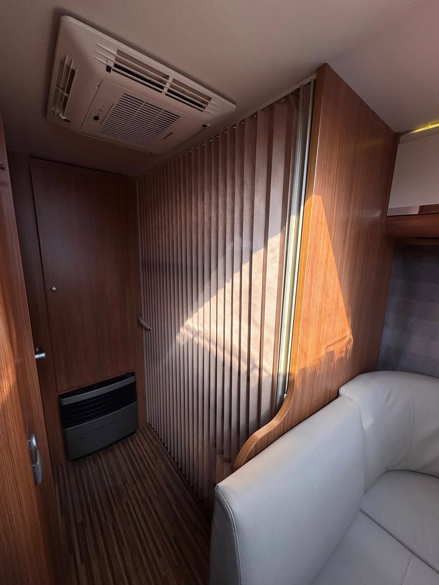 Obrázek interiéru obytného auta s moderním designem a příjemným osvětlením. Není uvedena značka ani model.