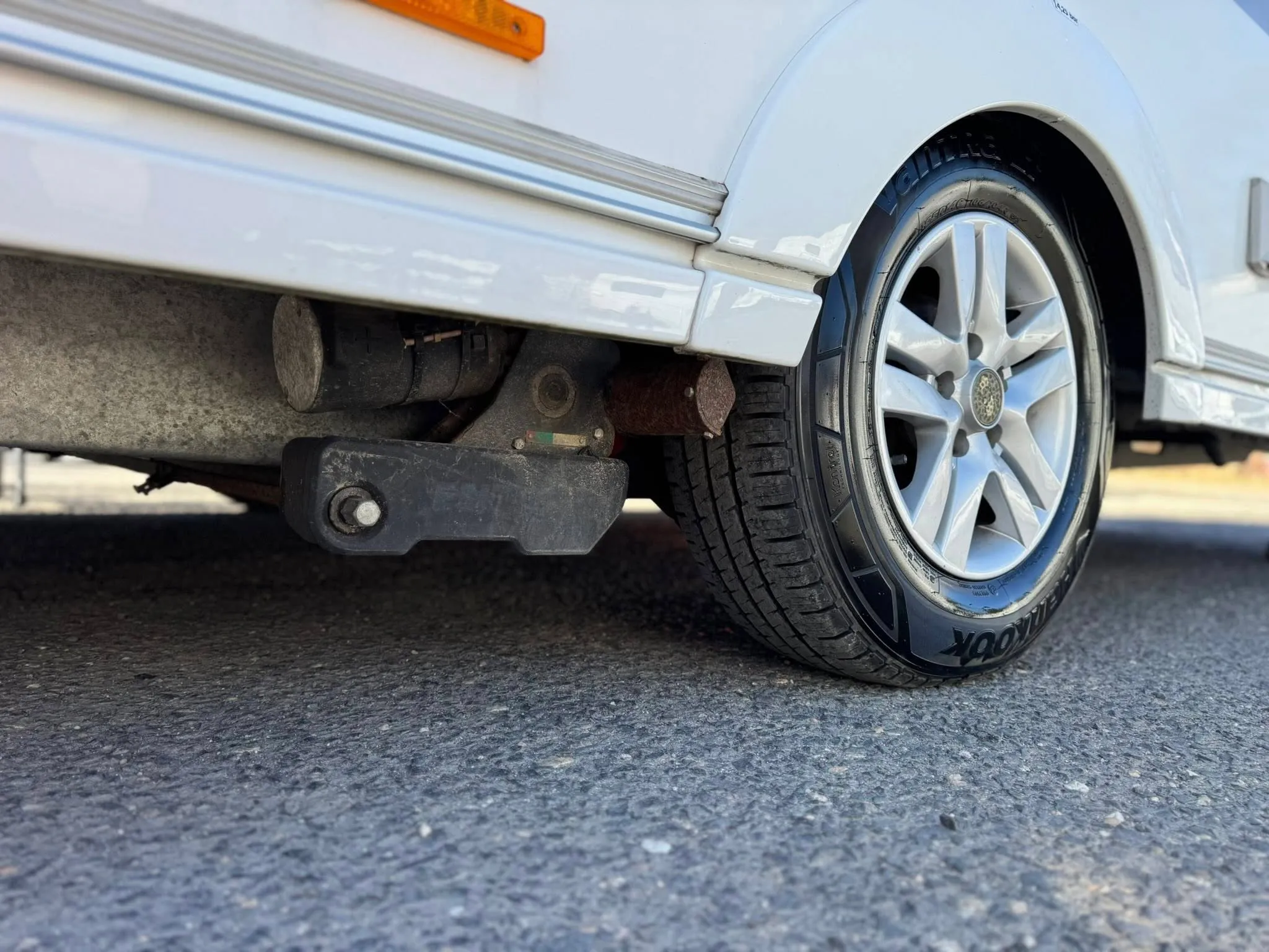 Obrázek ukazuje karavan s viditelnými koly a připojením. Ideální pro dobrodružství na cestách.