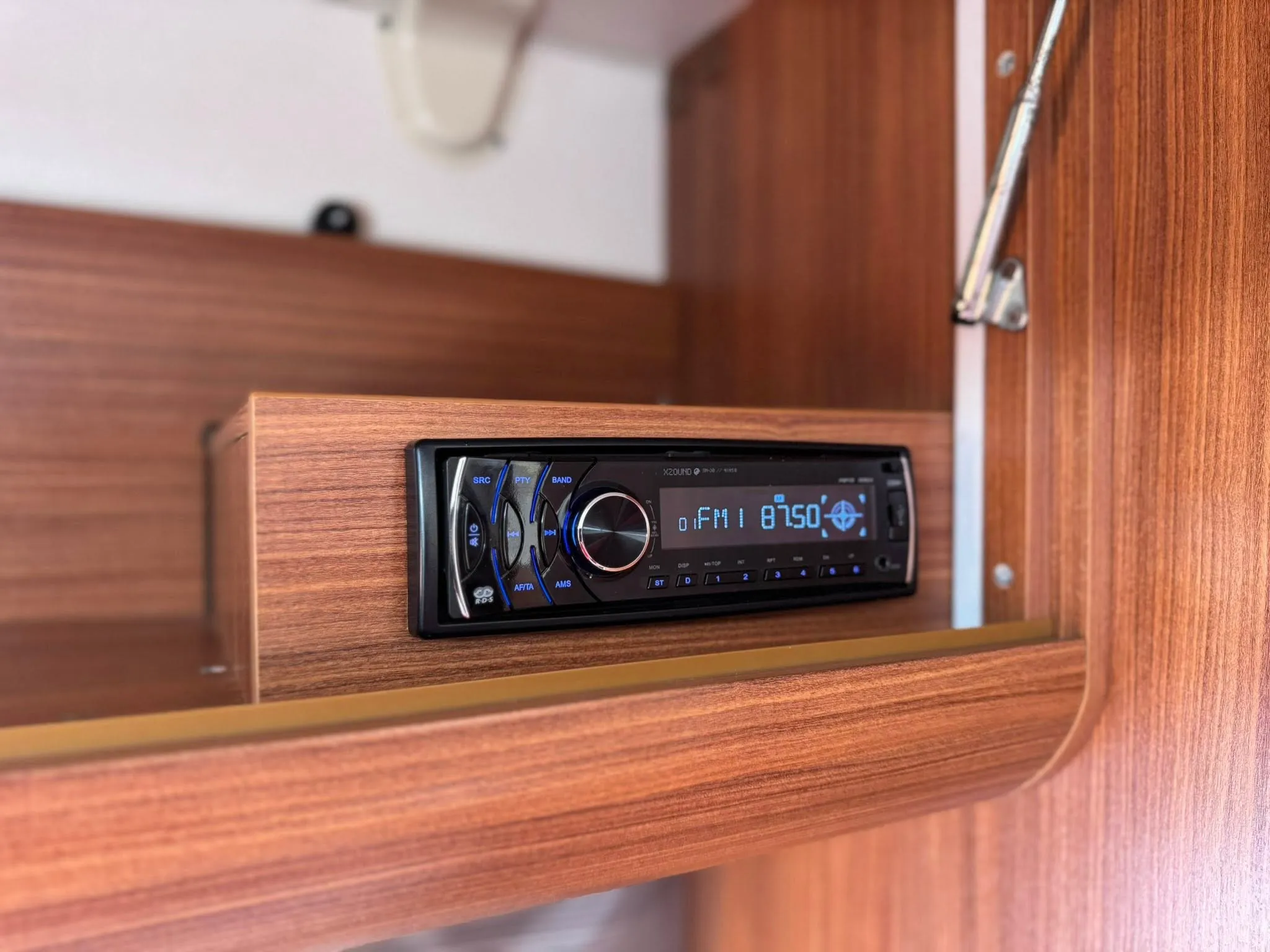 Na obrázku je rádio umístěné v interiéru obytného auta.