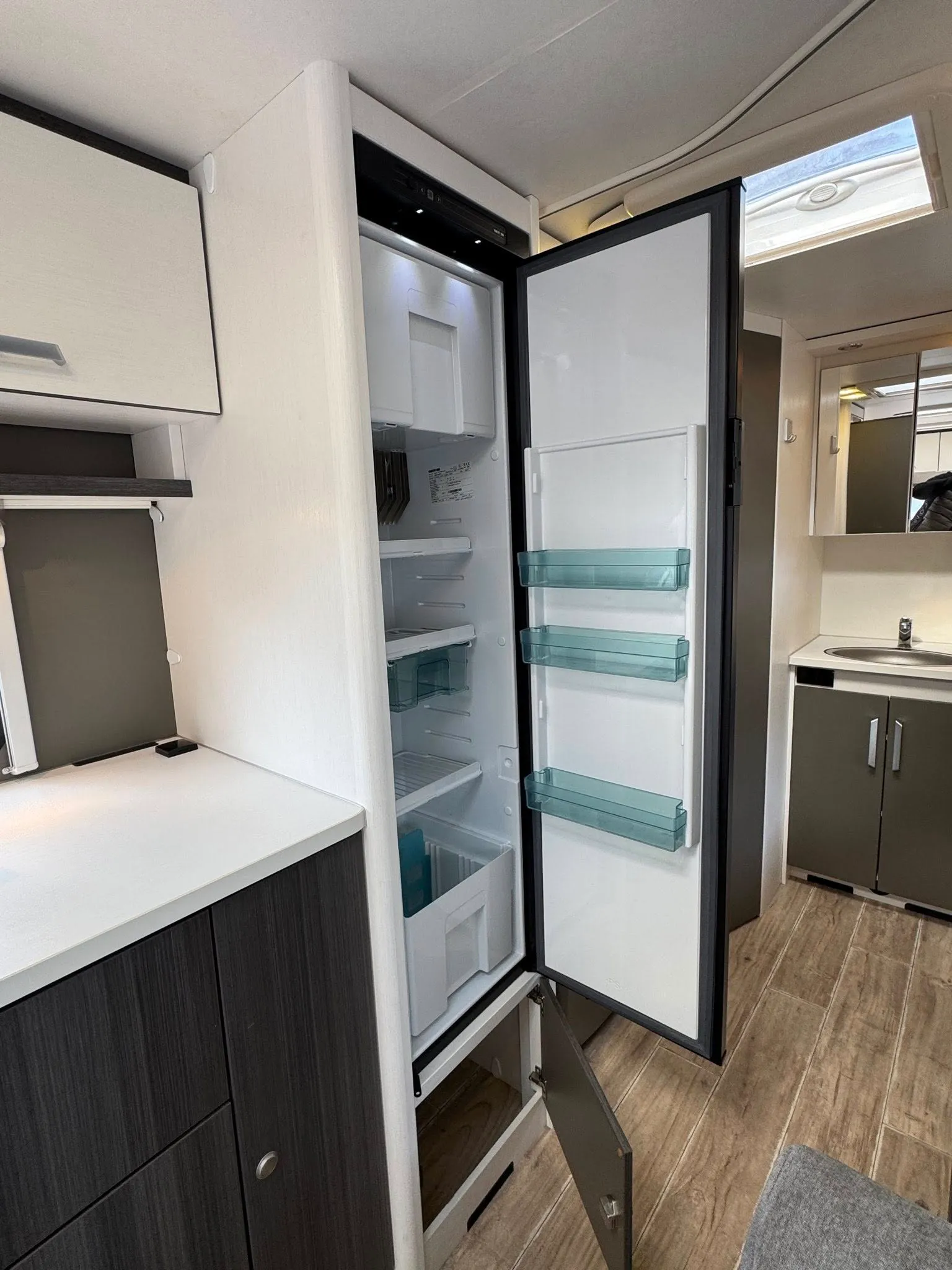 Obrázek interiéru s chladičem obytného vozu. Moderní a praktický design pro pohodlné cestování.