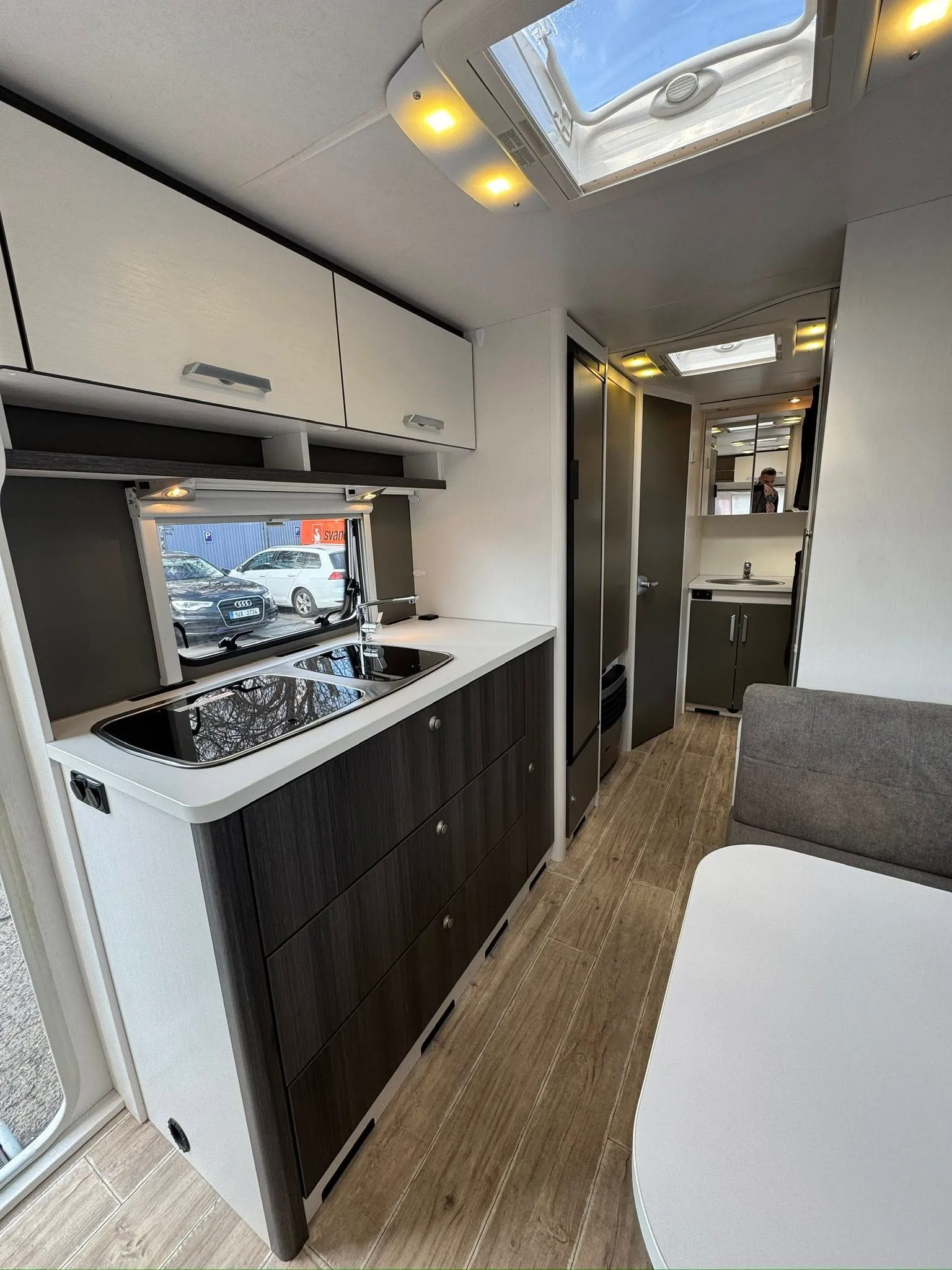 Interiér moderního karavanu s kuchyňkou a komfortním sezením. Ideální pro dobrodružství na cestách.