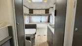 Interiér karavanu s moderním designem a prostorným uspořádáním, ideální pro pohodlné cestování.