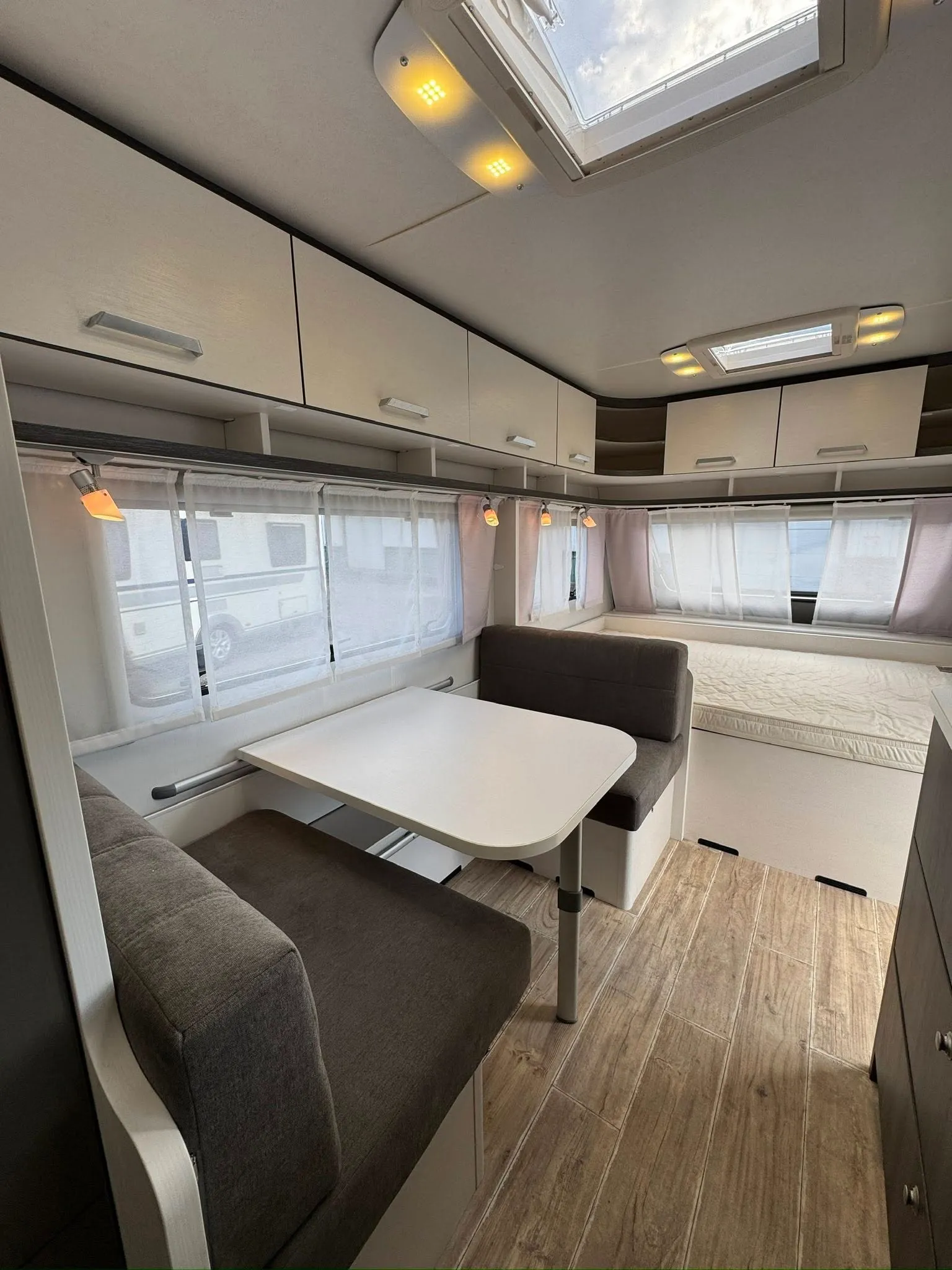 Interiér karavanu s pohodlným posezením a moderním designem. Ideální pro relaxaci na cestách.
