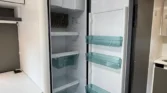 Obrázek zobrazuje chladničku uvnitř obytného vozu, ideální pro skladování potravin na cestách.