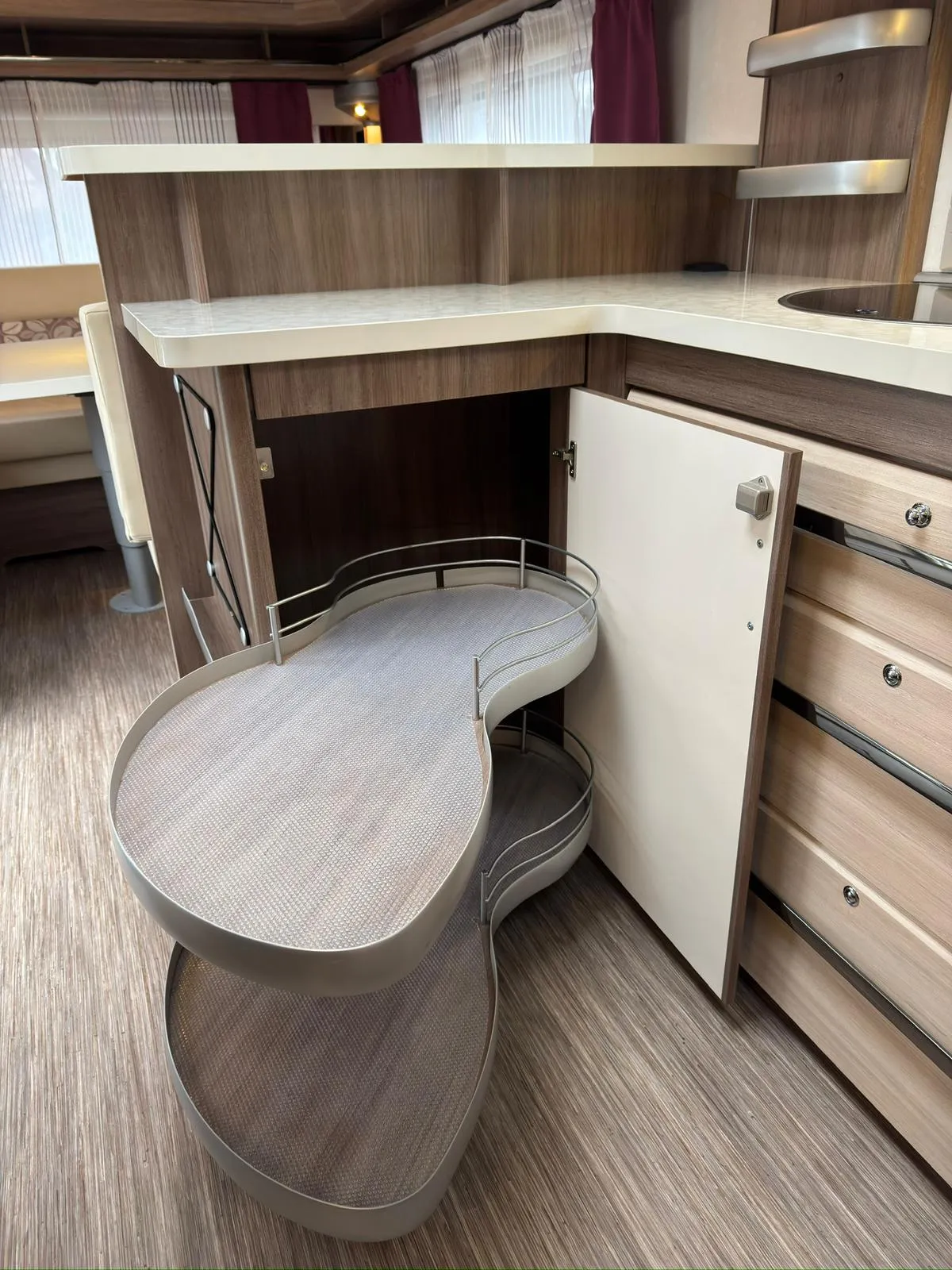 Obrázek interiéru karavanu s praktickým úložným prostorem v moderním designu. Ideální pro pohodlné bydlení na cestách.