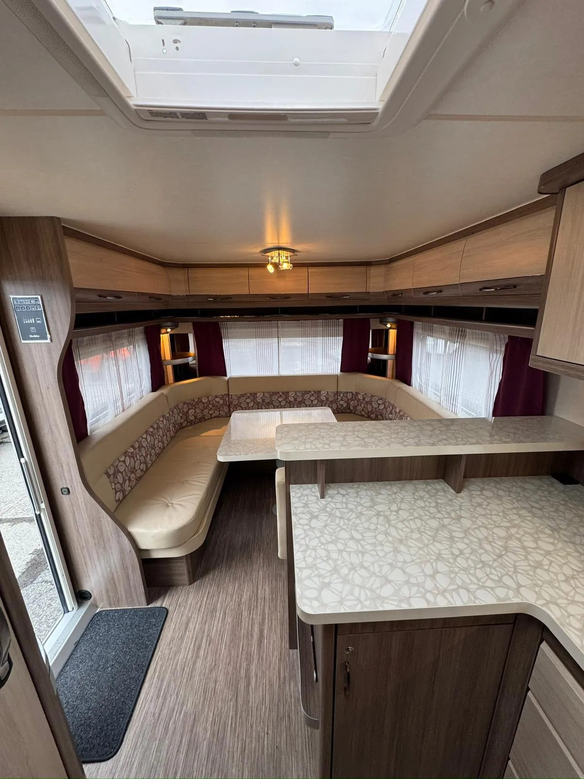 Interiér moderního karavanu s pohodlným sezením a praktickým stolkem. Ideální pro rodinné výlety.