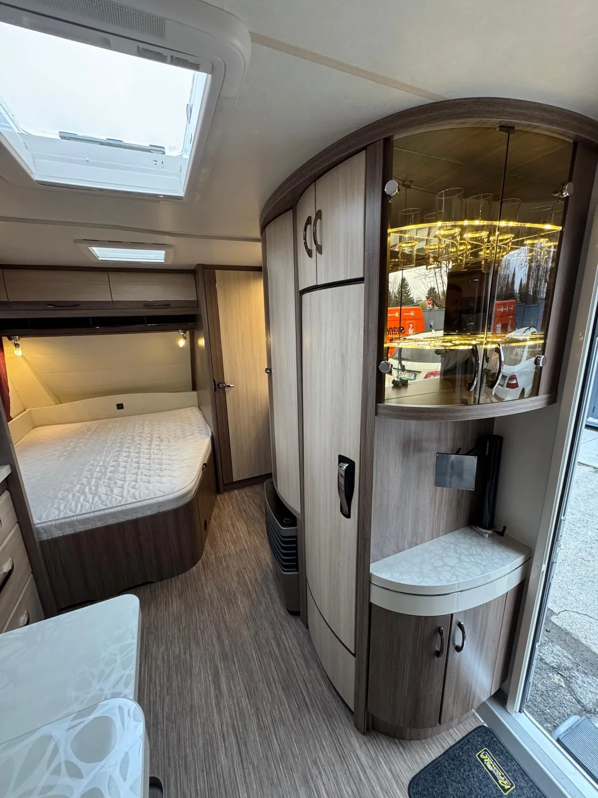 Interiér obytného vozu, moderní a útulný, s pohodlnou postelí a dostatkem úložného prostoru. Ideální pro dobrodružství.