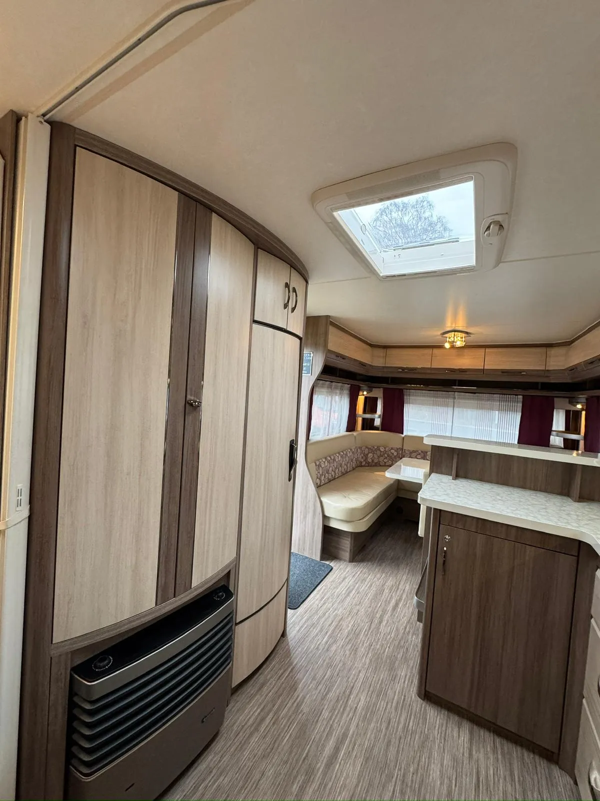 Toto je interiér karavanu s moderním designem a prostornou kuchyňkou. Vhodný pro pohodlné cestování.