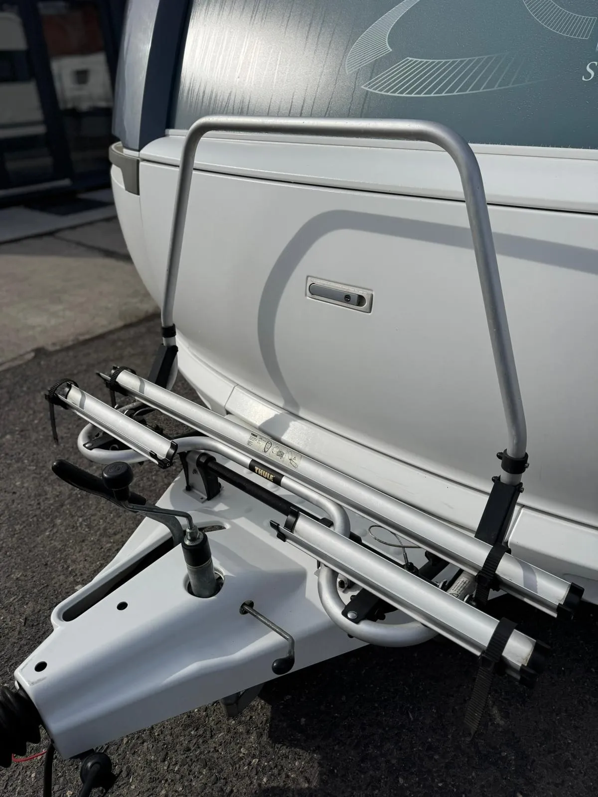 Na obrázku je přípojka karavanu s vybavením pro upevnění. Značka není viditelná.