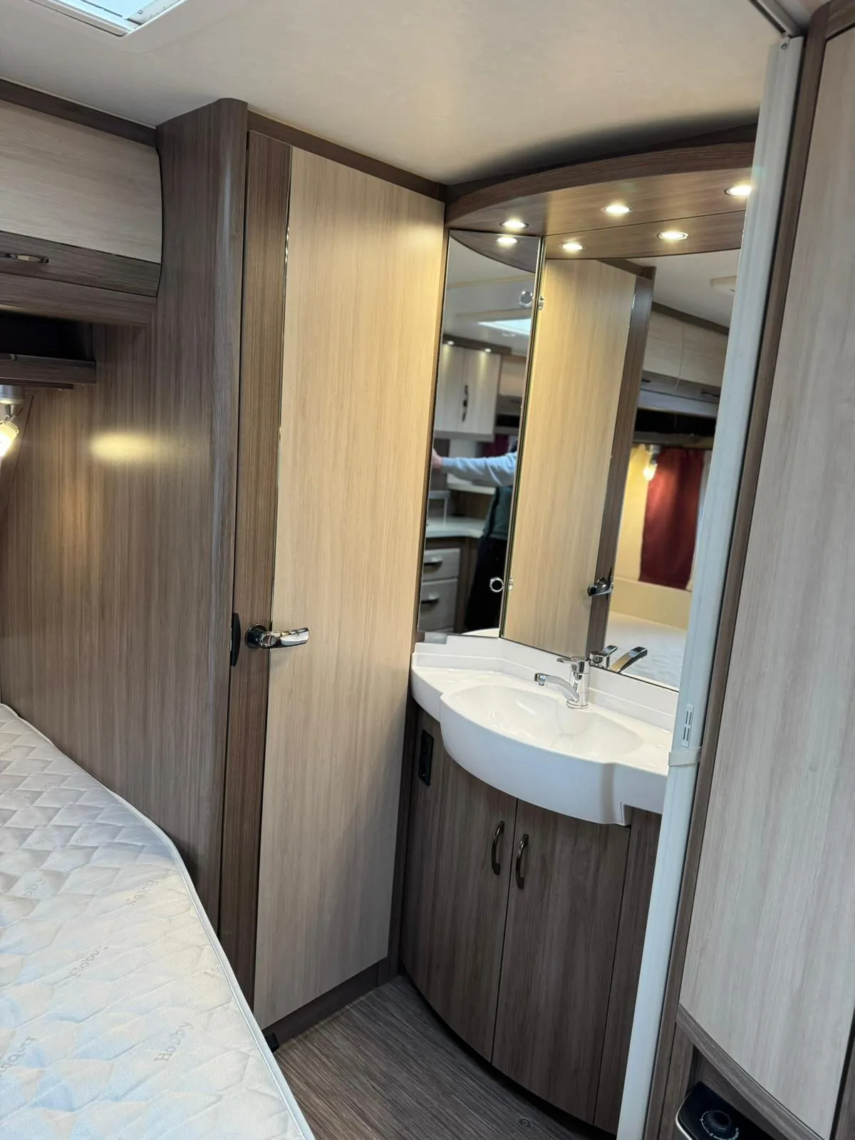 Obrázek interiéru karavanu, moderní zařízení a útulný design, ideální pro pohodlné cestování.