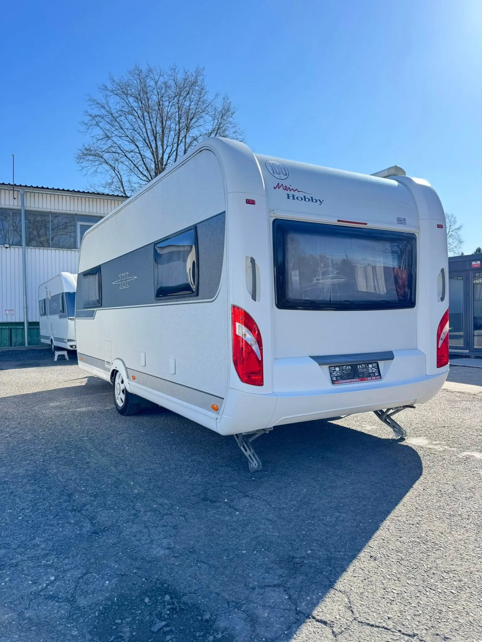 Karavan Hobby v moderním designu, ideální pro pohodlné cestování a dovolenou v přírodě.