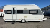Karavan Prestige, bílá barva, s velkými okny a stahovací stříškou, ideální pro dovolenou.