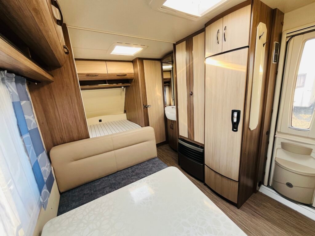 Interiér moderního karavanu s pohodlným uspořádáním a dostatkem úložného prostoru.