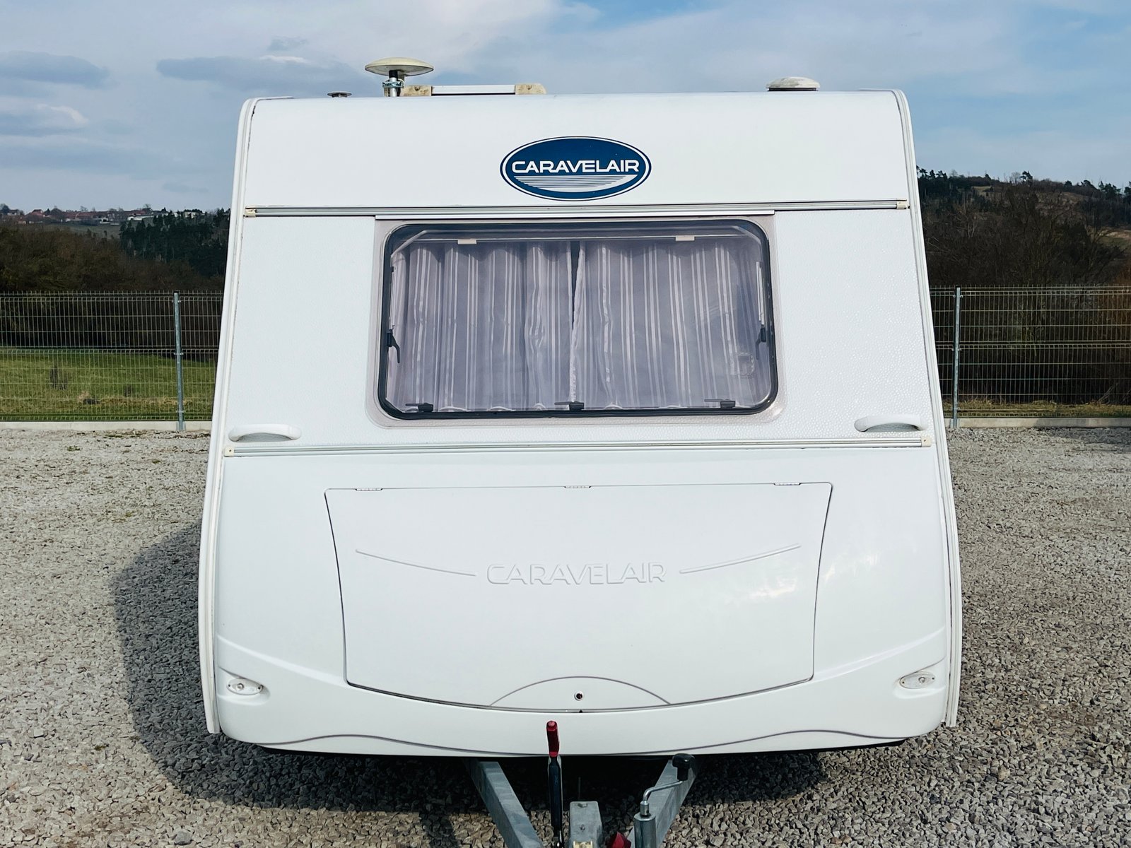 Karavan Caravelair v bílém provedení, ideální pro rodinné výlety a dovolené. Vhodný pro kempování a cestování.
