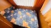 Obrázek ložnice v karavanu s barevným matrací. Příjemné prostředí pro odpočinek.