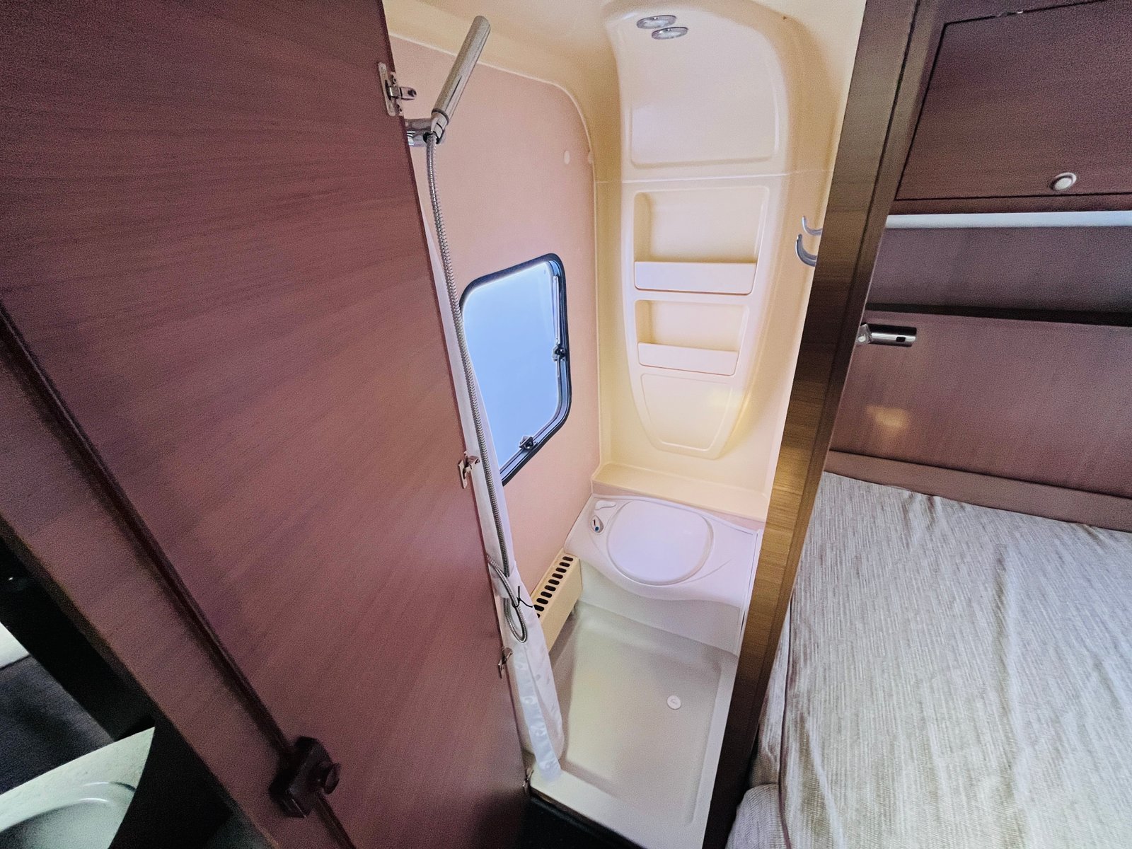 Obrázek zobrazuje koupelnu ve vozidle, možná obytném autě, ale bez viditelných detailů značky nebo modelu.