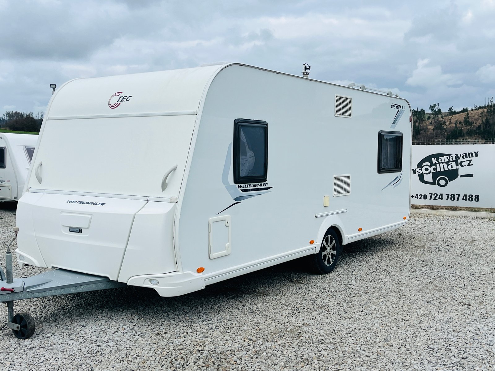 Karavan Weinsberg, model 525 TRW, bílý s moderním designem, ideální pro dobrodružství na cestách.