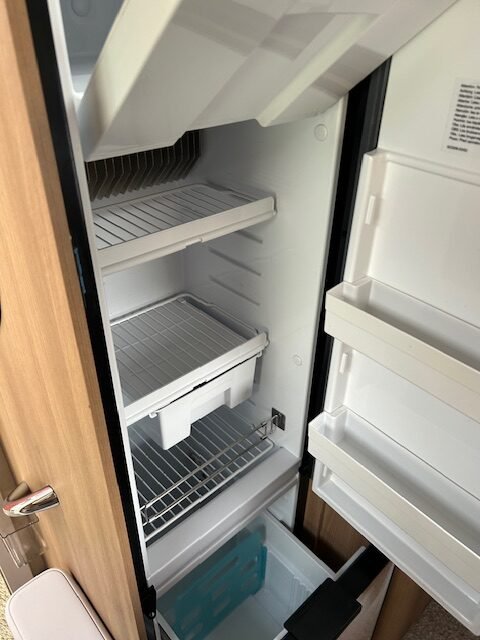 Interiér karavanu - chladnička s dostatkem prostoru pro potraviny a nápoje. Ideální pro cestování.