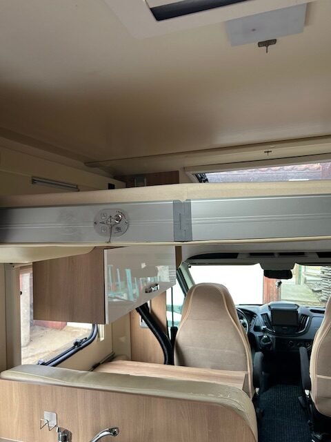 Interiér obytného auta s moderním designem a úložnými prostory. Značka a model nejsou viditelné.