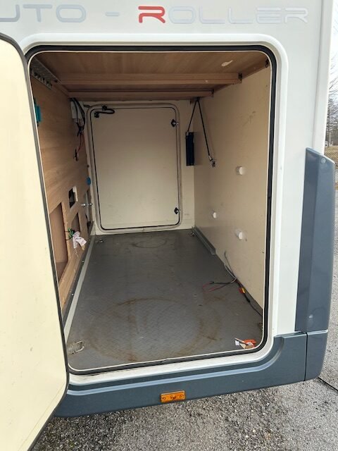 Obrázek znázorňuje karavan Auto-Roller s prázdným interiérem a otevřenými dveřmi.