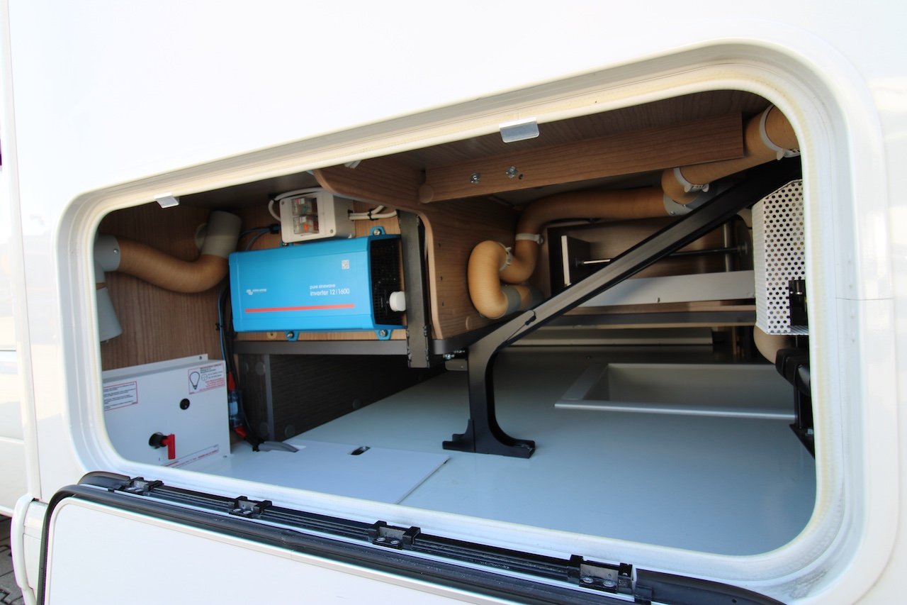 Obrázek interiéru obytného vozu s invertorem a instalací. Ideální pro pohodlné cestování.