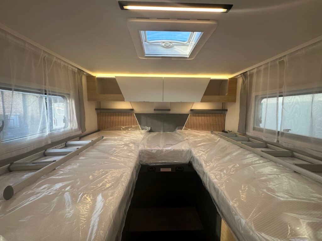 Kuchyňský interiér karavanu s moderním osvětlením a prostorem pokrytým ochrannou fólií.