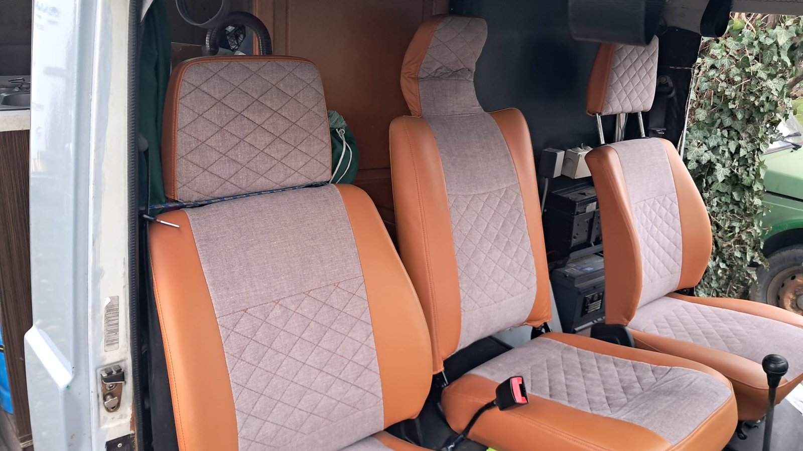 Interiér obytného auta s pohodlnými sedačkami v kombinaci hnědé a šedé barvy. Ideální pro cestování.