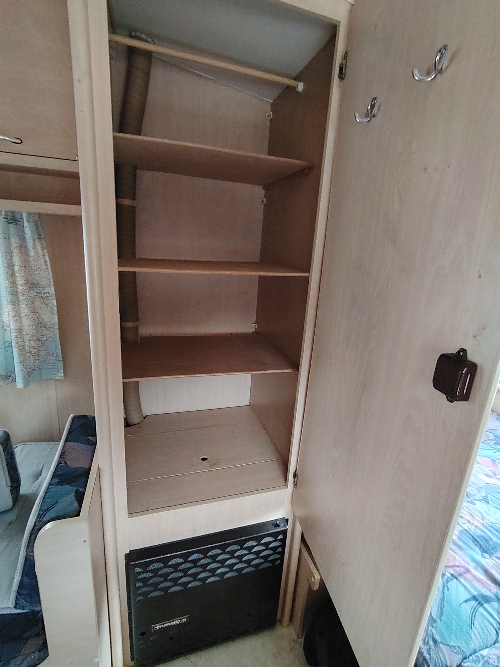 Interiér karavanu s úložným prostorem a lednicí. Ideální pro pohodlné cestování.