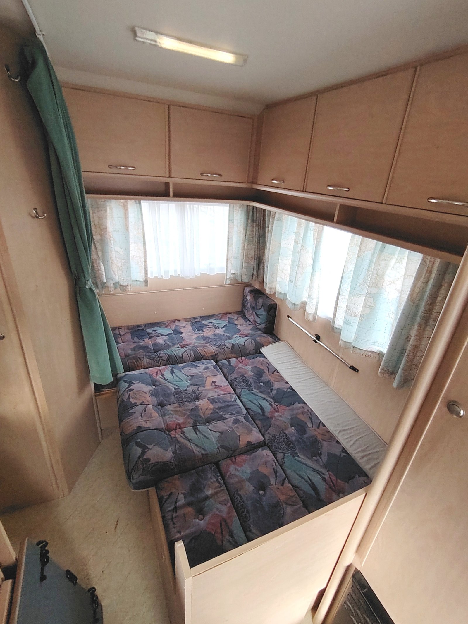 Interiér karavanu s pohodlnými lůžky a úložným prostorem. Ideální na cesty a rekreaci.