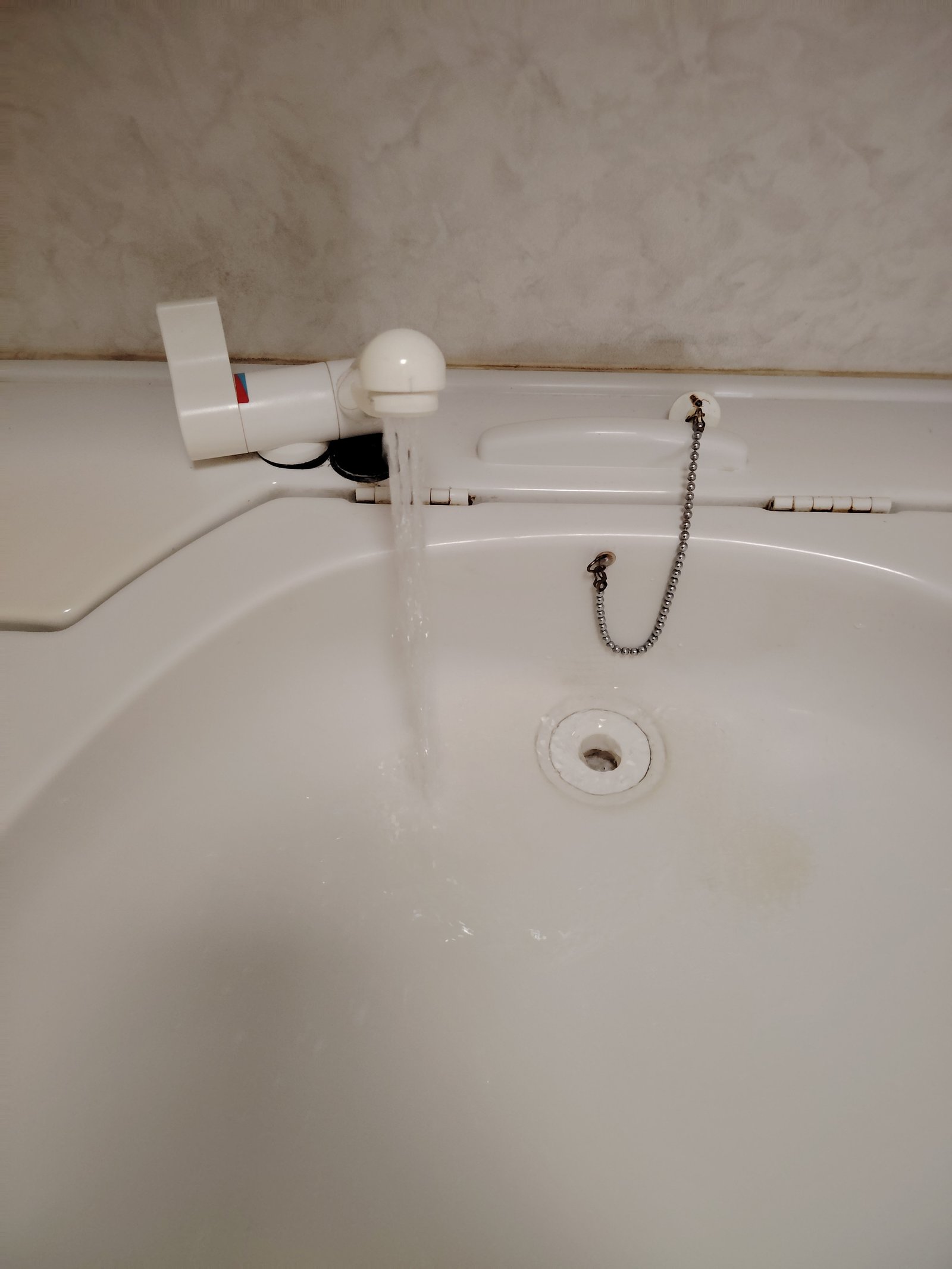 Obrázek zobrazuje umyvadlo s tekoucí vodou, ale nedá se určit, zda patří k obytnému autu či karavanu.