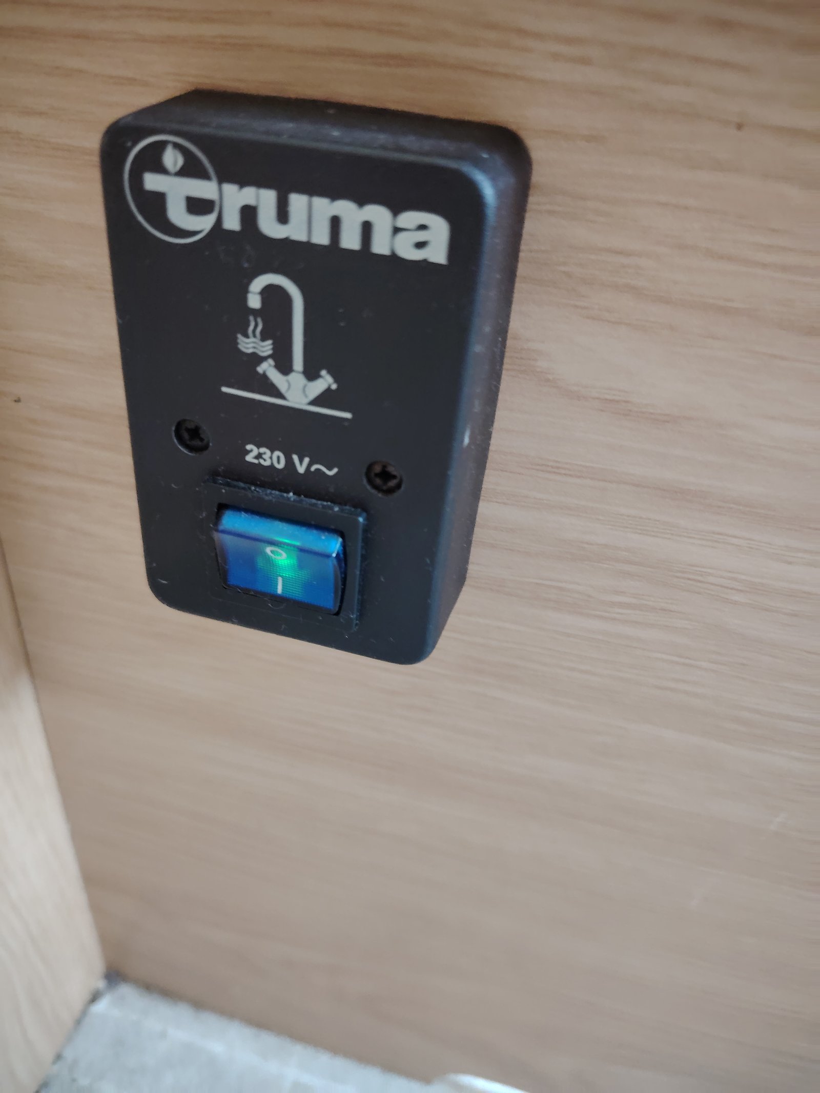 Na obrázku je spínač pro elektrické zařízení značky Truma, určený pro obytné vozy a karavany.