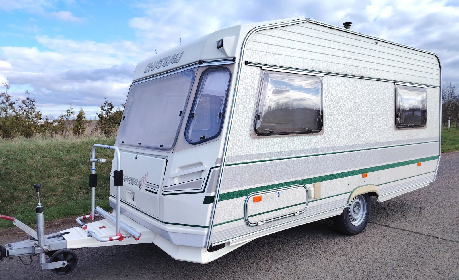 Karavan Chateau s bílou karosérií a zelenými doplňky, ideální pro pohodlné cestování.