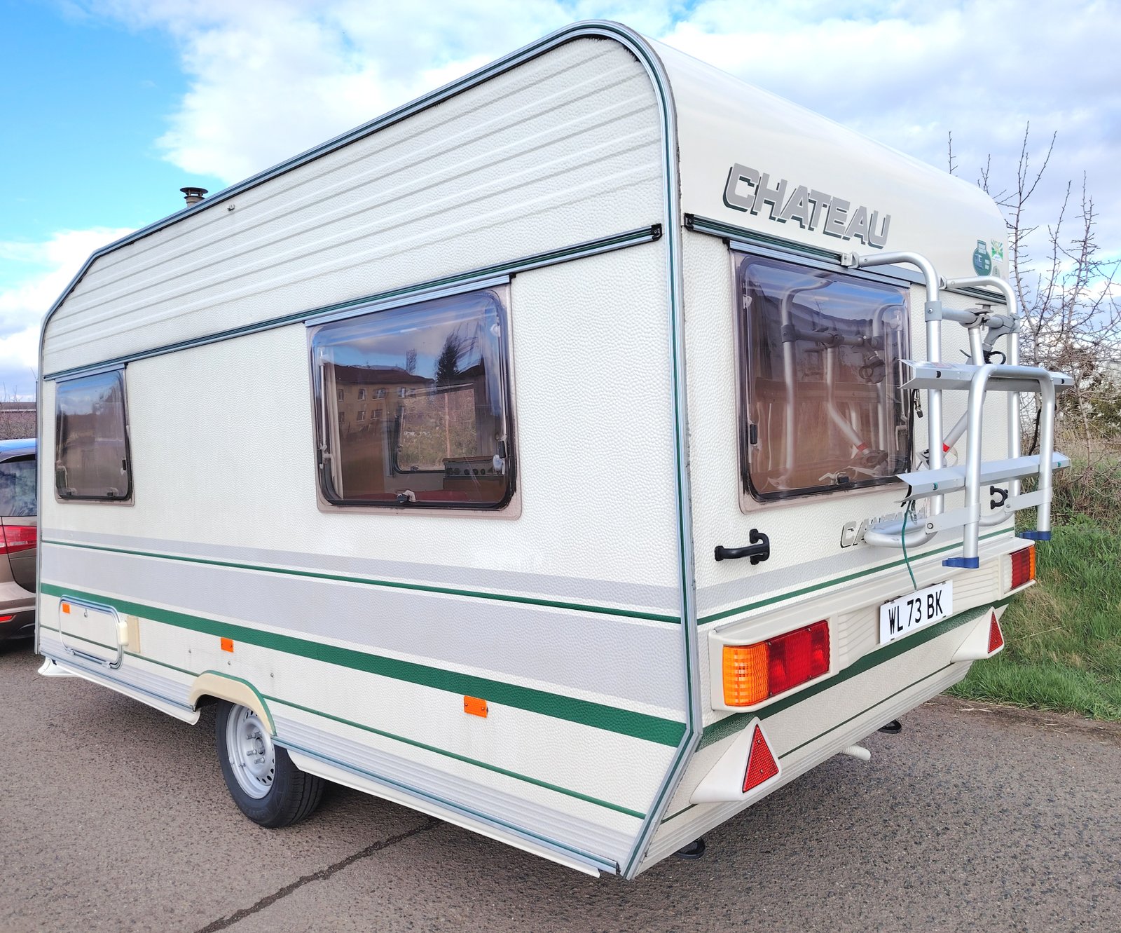 Karavan Chateau s bočními okny a stříškou, ideální pro pohodlné cestování a víkendové výlety.