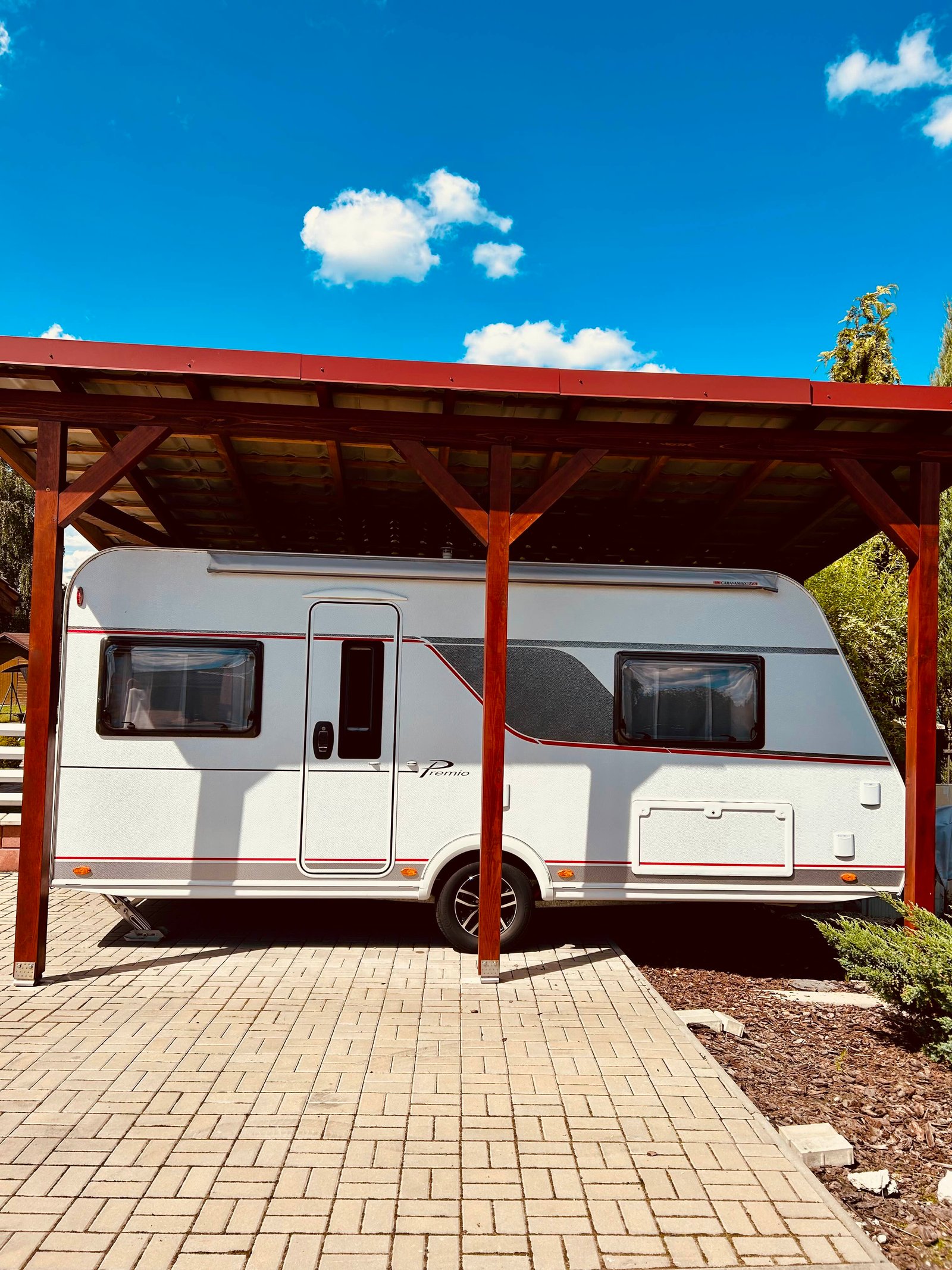 Karavan Premium pod přístřeškem, ideální pro pohodlné cestování a odpočinek v přírodě.