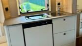 Moderní vybavení kuchyně v obytném autě s prostorem na vaření a úložným prostorem. Ideální pro kempování.