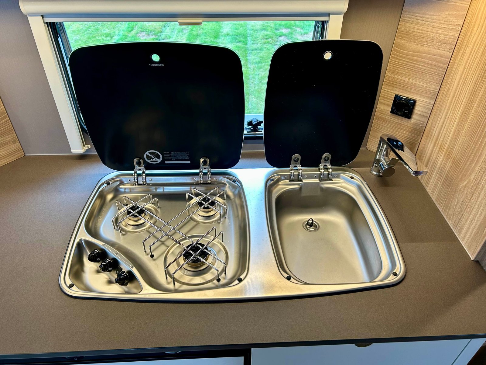 Kuchyňský kout v obytném voze s plynovým sporákem a dřezem. Ideální pro přípravu jídel na cestách.