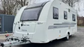 Karavan Adria Adora 532 DP v bílé barvě se moderním designem, ideální pro cestování a dovolené.