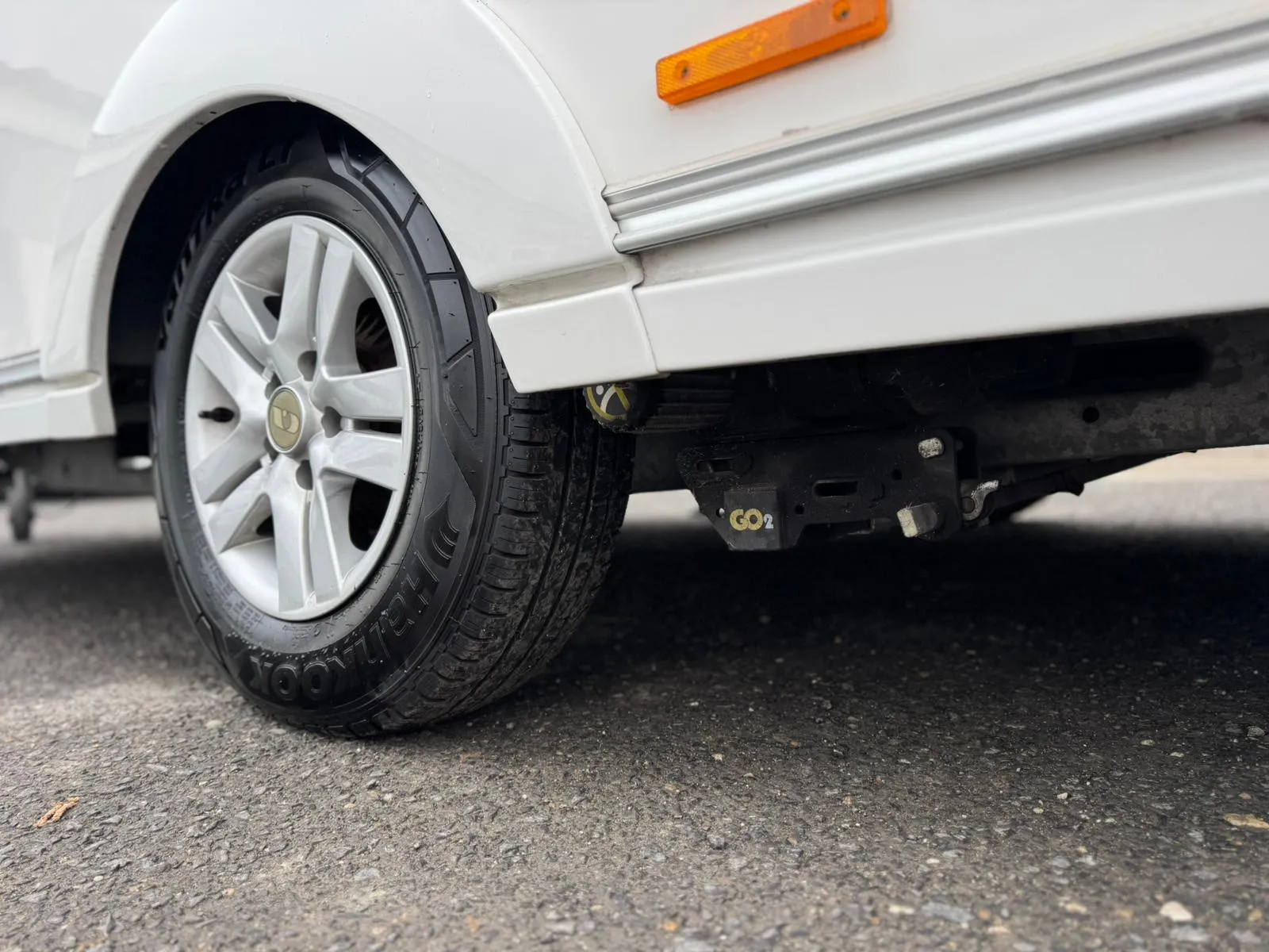 Obrázek zobrazuje zadní kolo obytného auta s nájezdem. Značka a model nejsou viditelné.