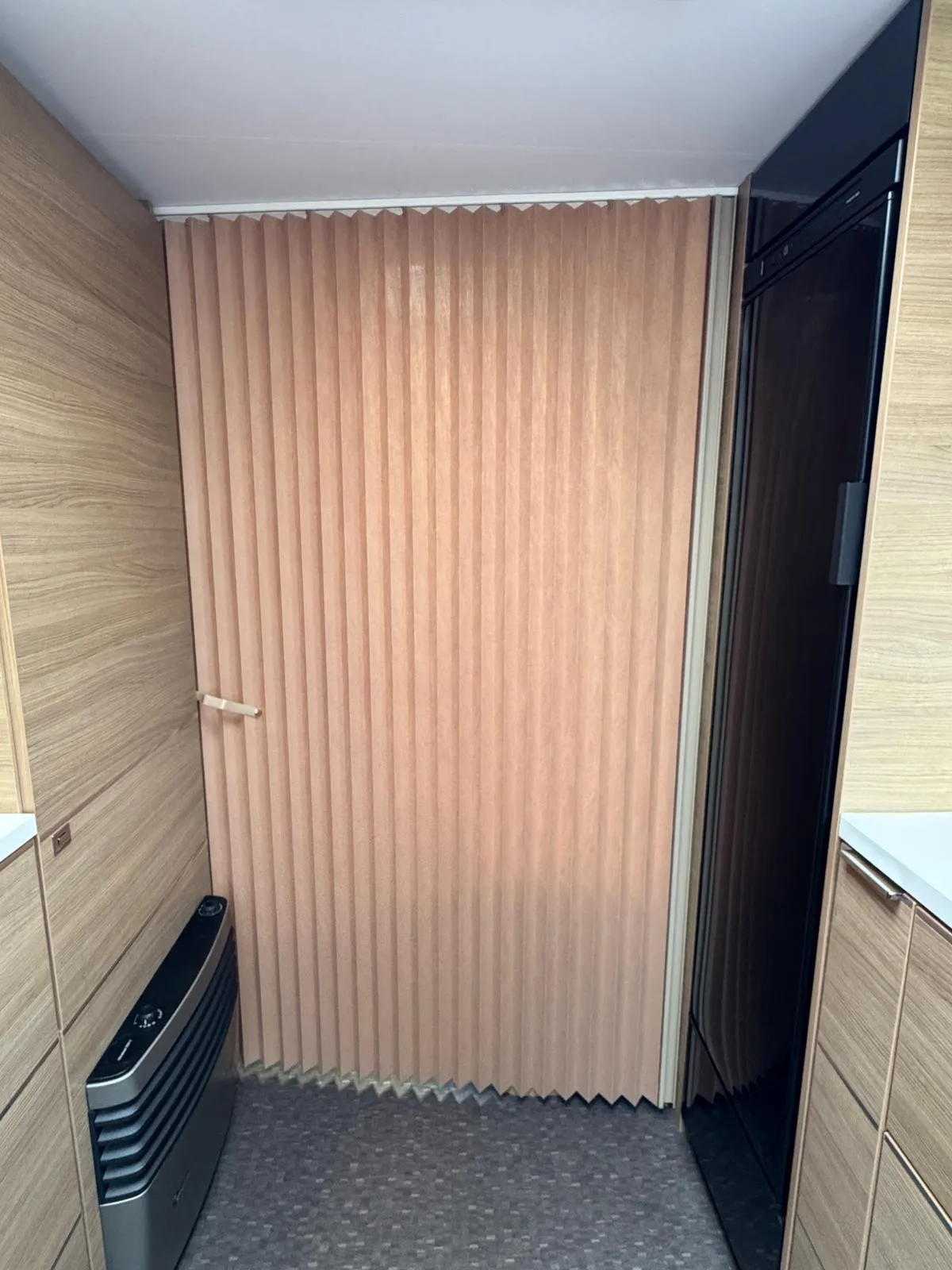 Obrázek interiéru karavanu s moderním designem a dřevěnými prvky. Ideální pro pohodlné cestování.