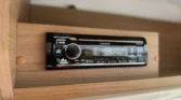 Obrázek ukazuje rádio Kenwood v obytném voze, ideální pro vytvoření pohodové atmosféry na cestách.