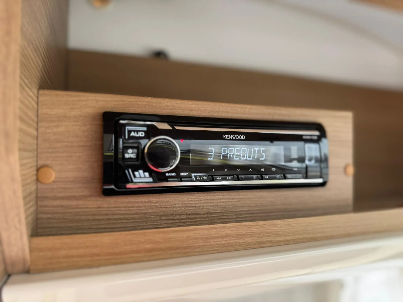 Obrázek ukazuje rádio Kenwood v obytném voze, ideální pro vytvoření pohodové atmosféry na cestách.