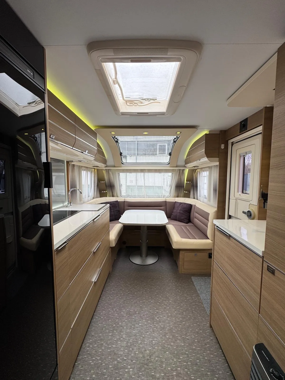 Interiér moderního karavanu s stylovým uspořádáním a pohodlným sezením pro relaxaci.