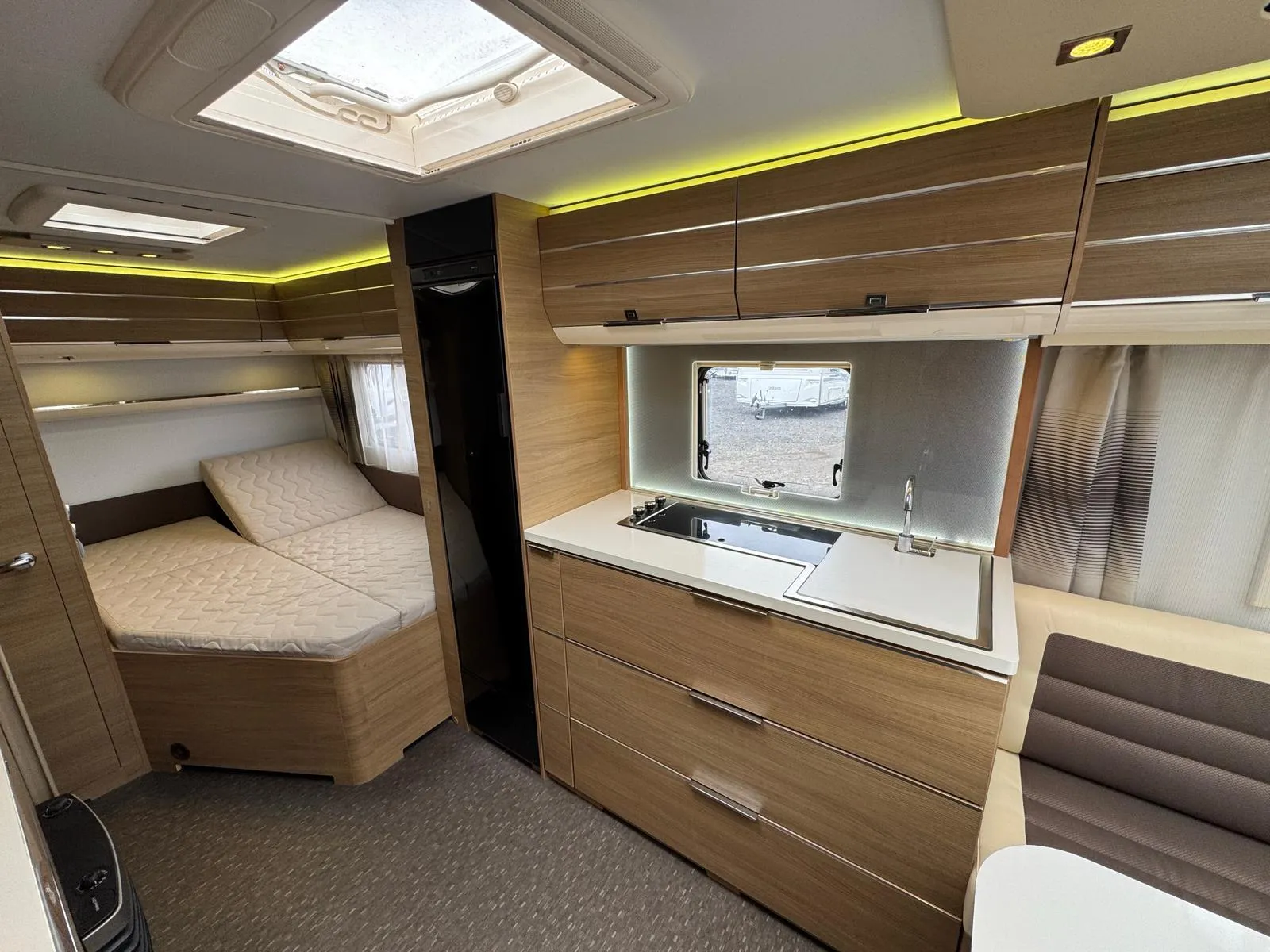 Moderní karavan s prostorným interiérem, kuchyňským koutem a pohodlnou ložnicí. Ideální pro pohodové cestování.