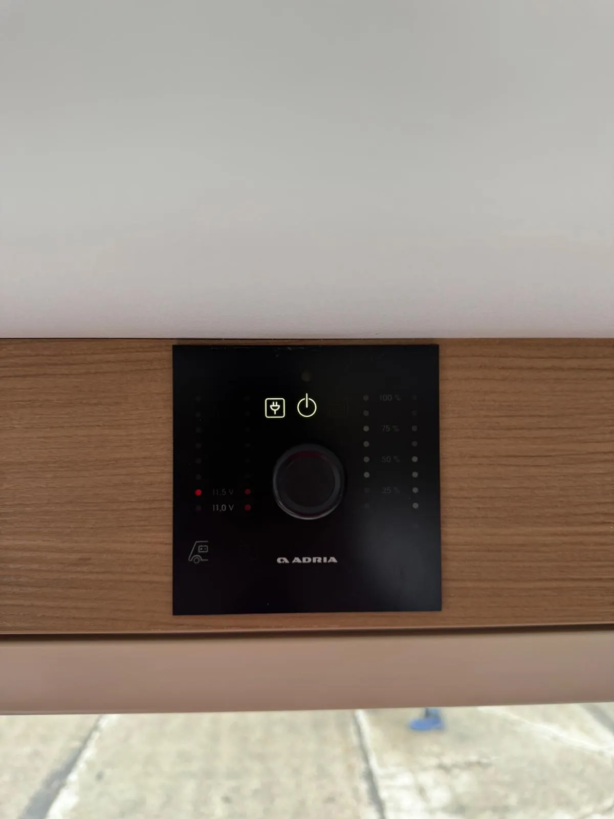 Ovládací panel obytného auta Adria s indikátory napětí a funkcí zapnutí/vypnutí.