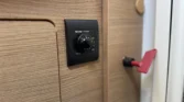 Obrázek ukazuje ovladač Truma Ultraheat v interiéru obytného vozu, ideální pro komfortní kempování.