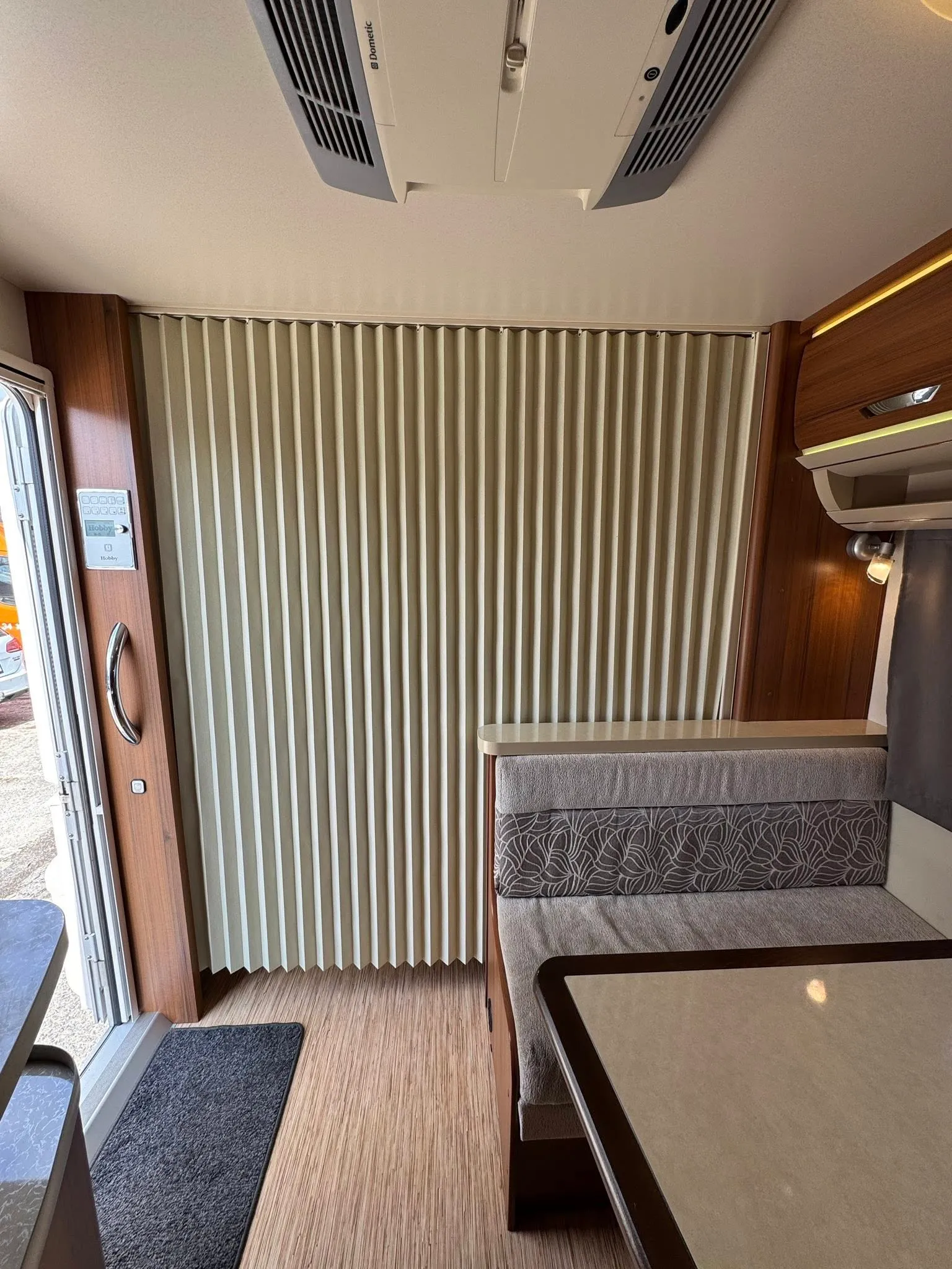 Obrázek interiéru karavanu s moderním designem a pohodlným sezením. Ideal pro relaxaci na cestách.