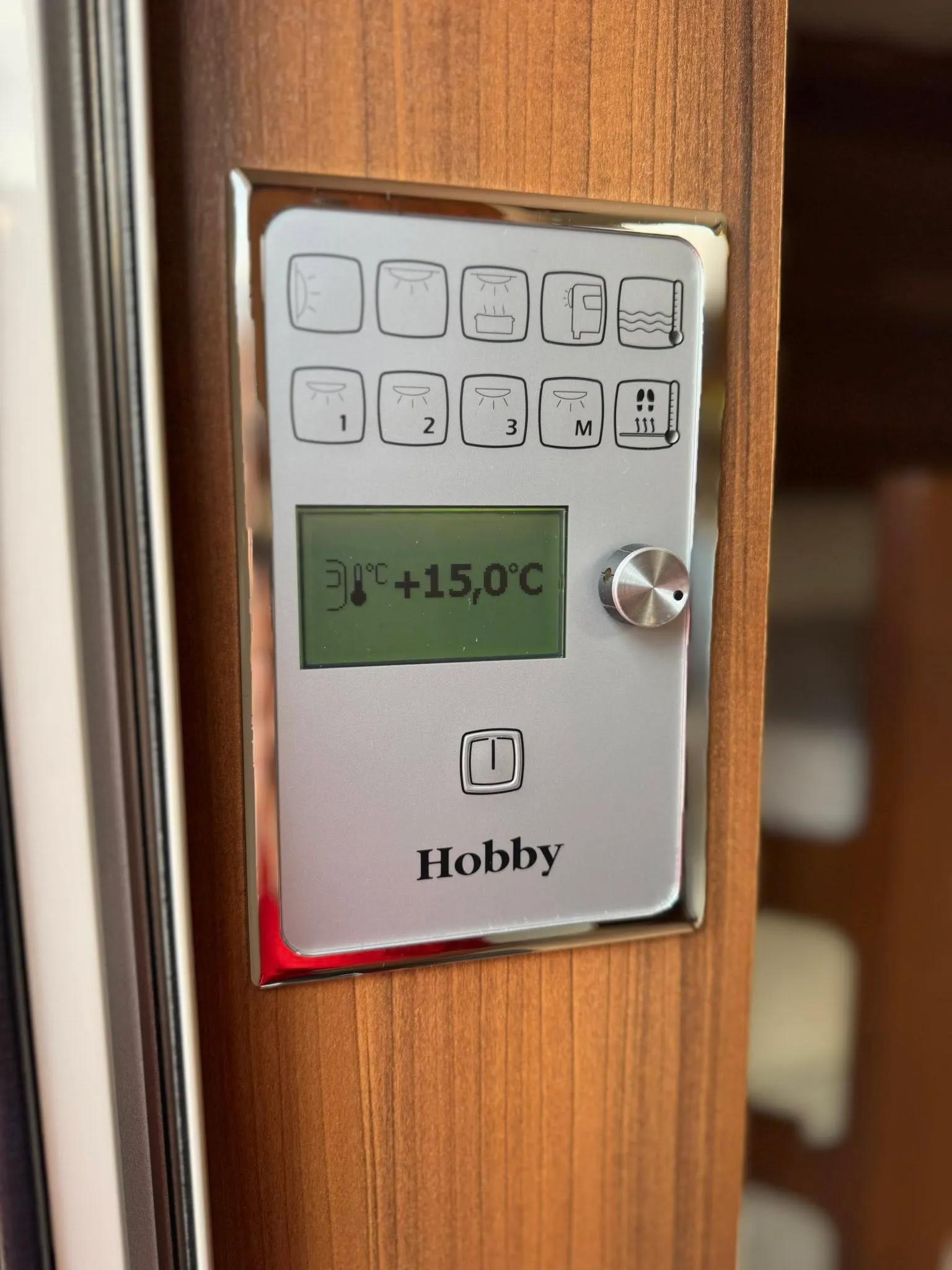 Ovládací panel obytného vozu Hobby s nastavením teploty a osvětlení. Ideální pro pohodlné kempování.