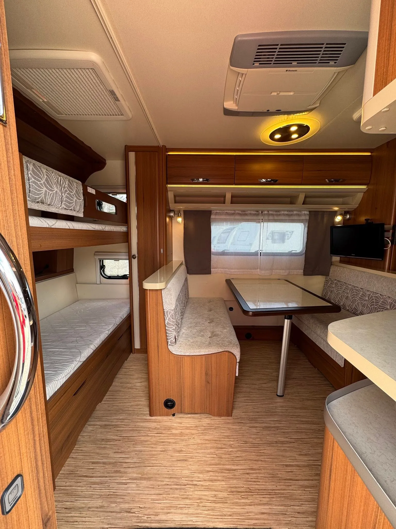 Moderní interiér karavanu s prostorným obývacím prostorem a pohodlným sezením. Ideální pro rodinné výlety.